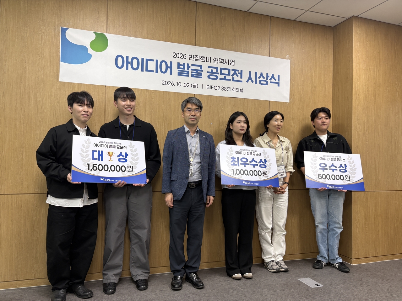 Participants pose for a group photo at the awards ceremony for the vacant-home revitalization idea contest on Friday. [HUG]