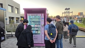 Festivalgoers grab Seoul souvenirs from vending machines