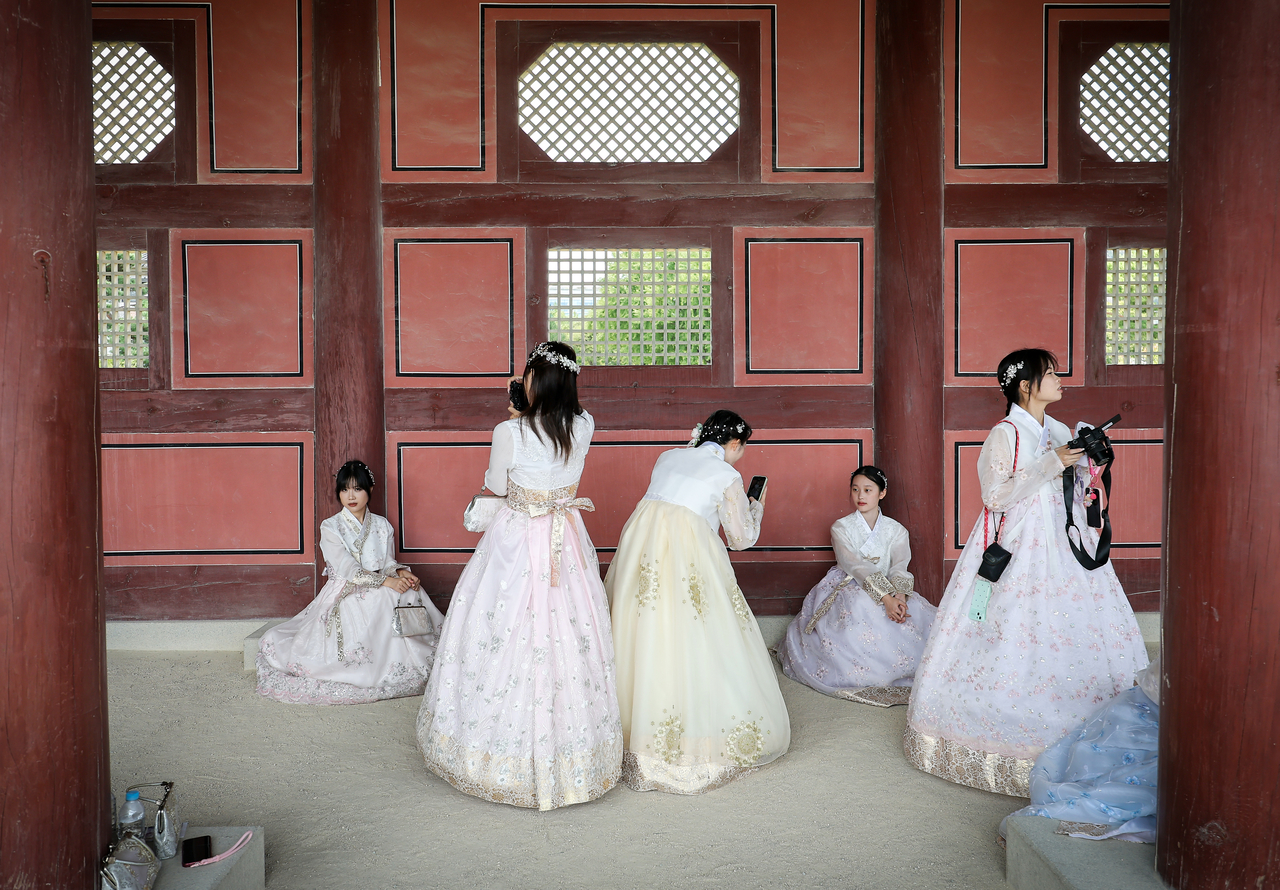 People take photos at Gyeongbokgung in Jongno-gu, central Seoul, on Sunday. (Yonhap)