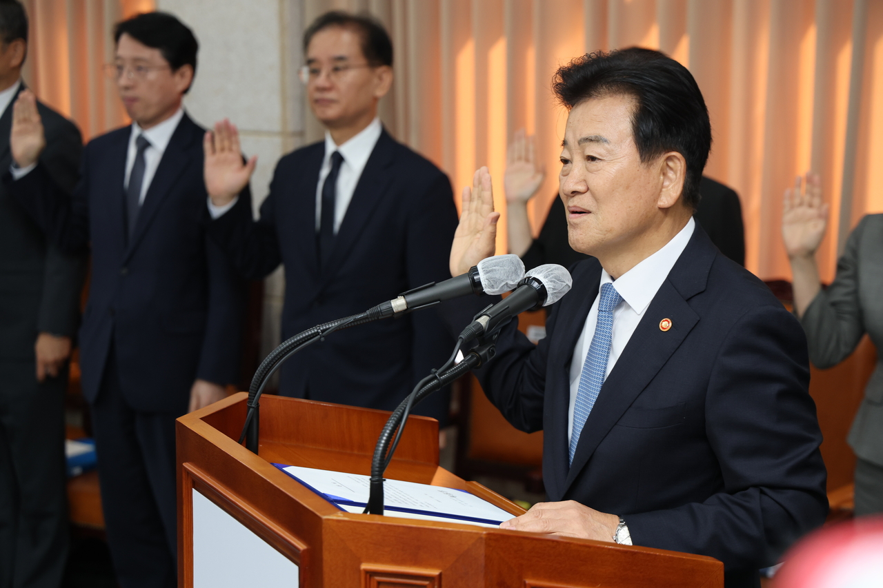 Unification Minister Chung Dong-young (R) takes an oath at a parliamentary audit of the ministry at the Office of Inter-Korean Dialogue in Seoul on Wednesday. (Yonhap)