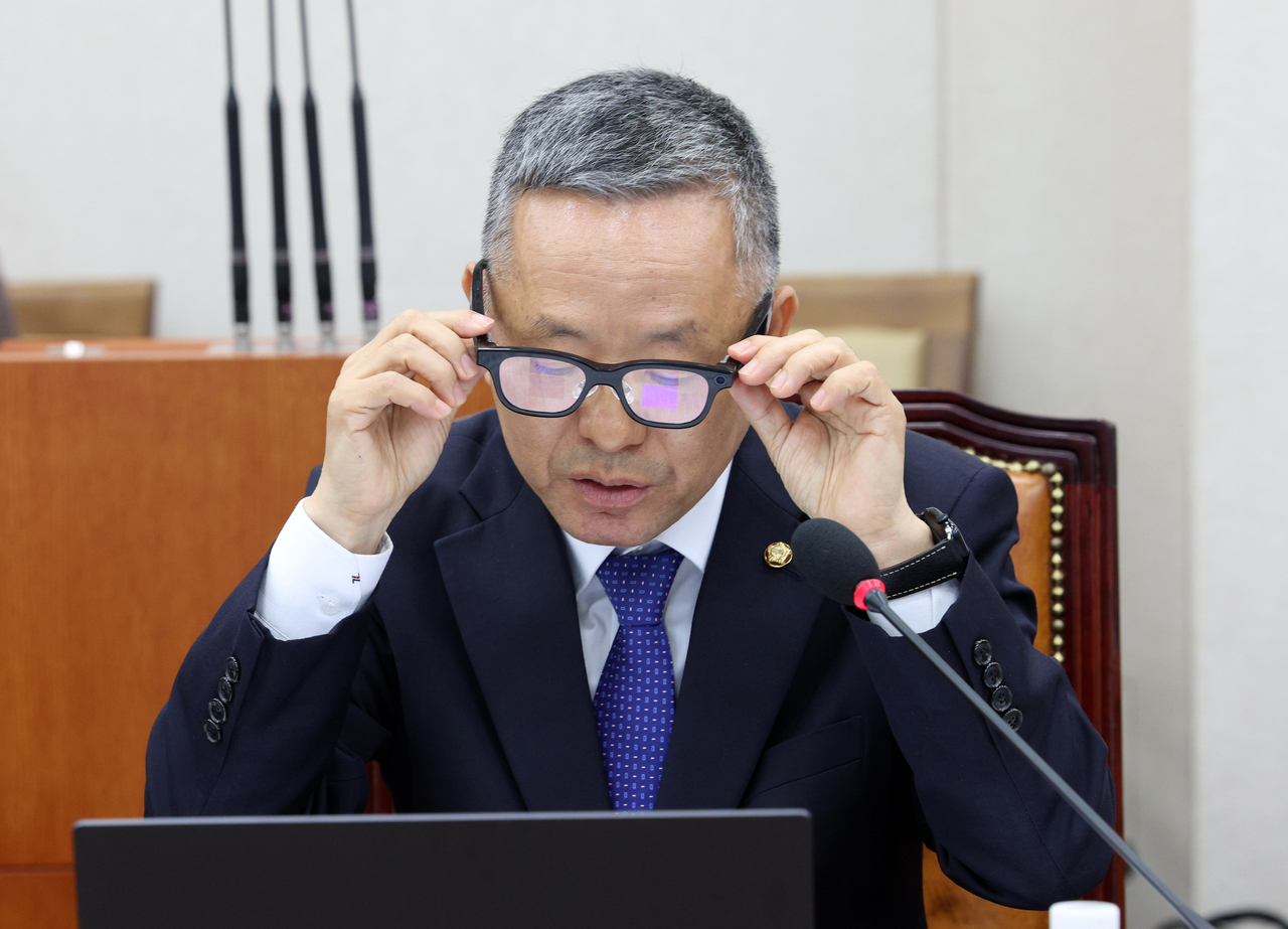 Democratic Party of Korea Rep. Kim Moon-soo puts on an AI-powered glasses during a parliamentary audit at the Nationals Assembly on Wednesday. (Newsis)