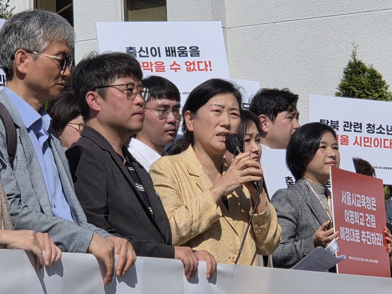 Yeomyung School Principal Cho Myung-sook (third from left) calls for the construction of a permanent campus during a press conference outside the Seoul Metropolitan Council in Seoul on Wednesday. (Hwang Sun-jun/The Korea Herald)