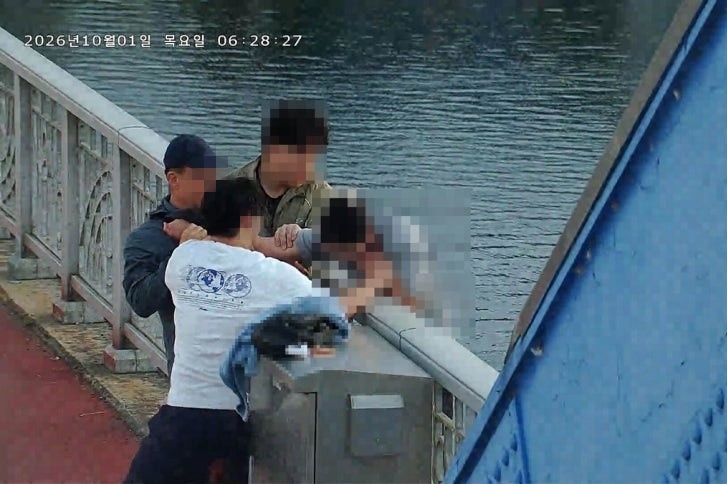 다리 난간 밖 시민 구하는 모습. [강원도소방본부]