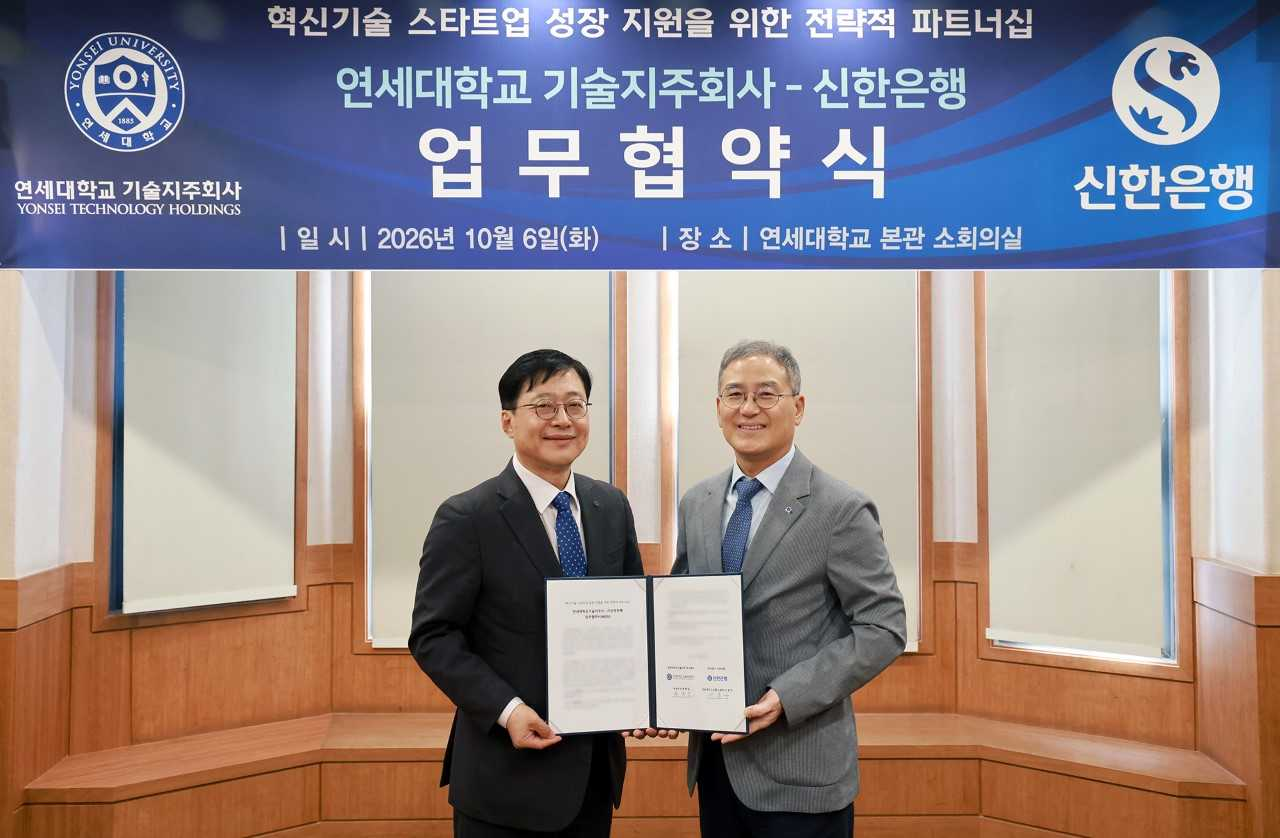 Lee Jong-gu (left), head of Shinhan Bank's Sales Promotion Group 1, and Hong Jong-il, chief executive of Yonsei University Technology Holdings, pose for a photo at the signing ceremony for the "Strategic Partnership for Supporting the Growth of Innovative Technology Startups" at Yonsei University's main building in Seodaemun-gu, Seoul, on Tuesday. [Shinhan Bank]