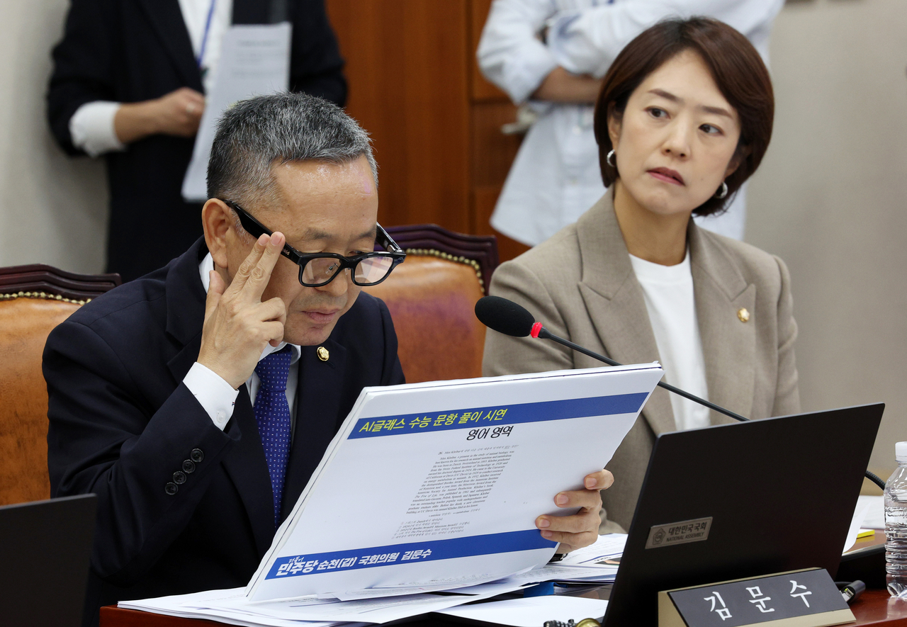 Democratic Party of Korea Rep. Kim Moon-soo touches the side of his AI-powered glasses during a parliamentary audit at the National Assembly on Wednesday, as he uses the device to solve a question on the English section of South Korea's College Scholastic Ability Test, or Suneung. (Newsis)