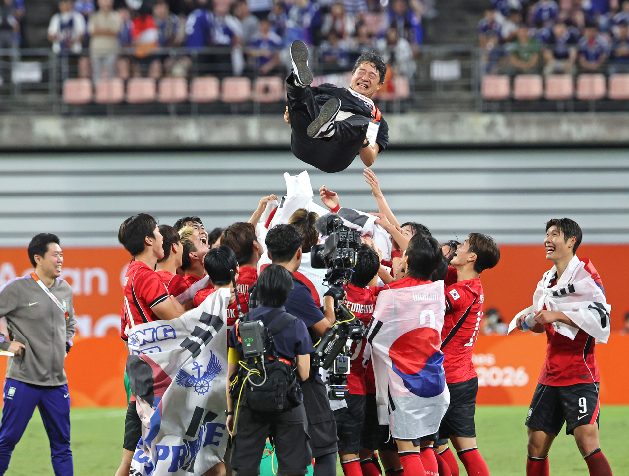 South Korean players toss head coach Lee Min-sung into the air after winning the gold medal in the men's football final against Japan at Toyota Stadium in Aichi Prefecture, Japan, on Saturday. [Yonhap]