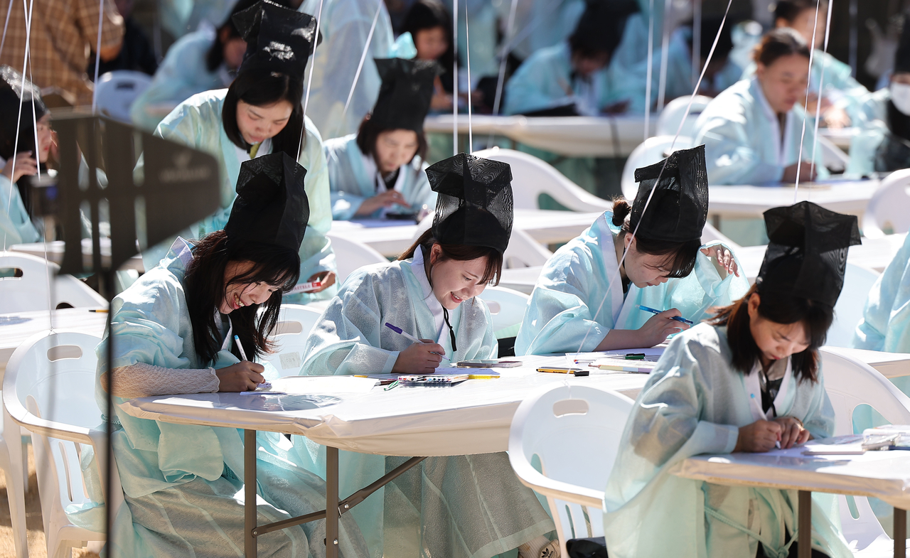 Foreign nationals and members of multicultural families compose five-line acrostic poems in Korean during a writing contest celebrating Hangeul Day at Byeongam Seowon in Dalseo-gu, Daegu, Wednesday. (Yonhap)