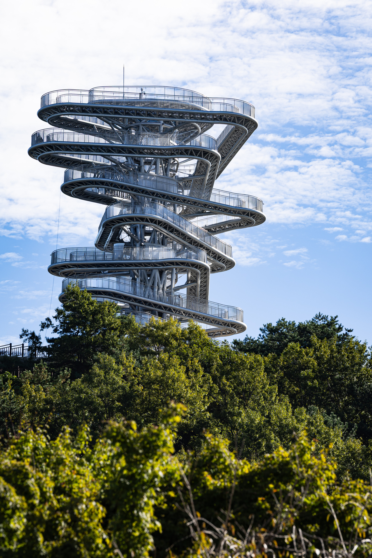"Panorama Walk," an interactive sculptural installation at the summit of Gubongsan in Gwangyang. Standing 27 meters tall with a track length of about 365 meters, the structure lets visitors walk through it while overlooking Gwangyang Bay and the surrounding mountains. [Posco]