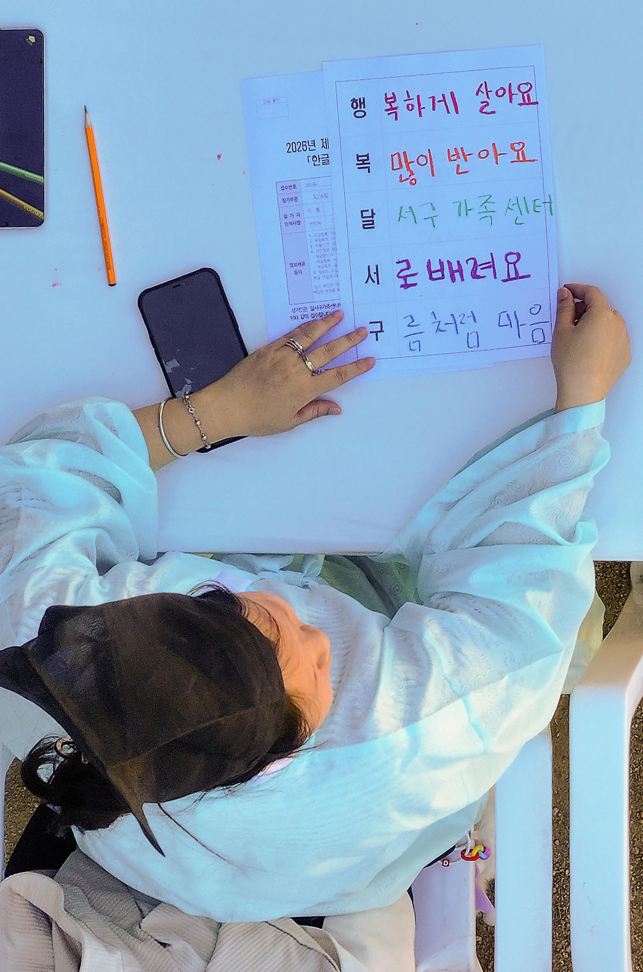 A participant composes a five-line acrostic poem using the Korean phrase "Happy Dalseo-gu" during a writing contest celebrating Hangeul Day at Byeongam Seowon in Dalseo-gu, Daegu, Wednesday. (Yonhap)