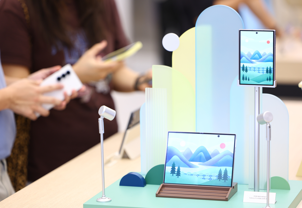 Visitors examine Samsung Electronics' Galaxy Z Fold8 and Flip8 smartphones at Samsung Gangnam in southern Seoul on Aug. 4. The new foldable lineup drew a record 1.44 million preorders in South Korea. (Newsis)