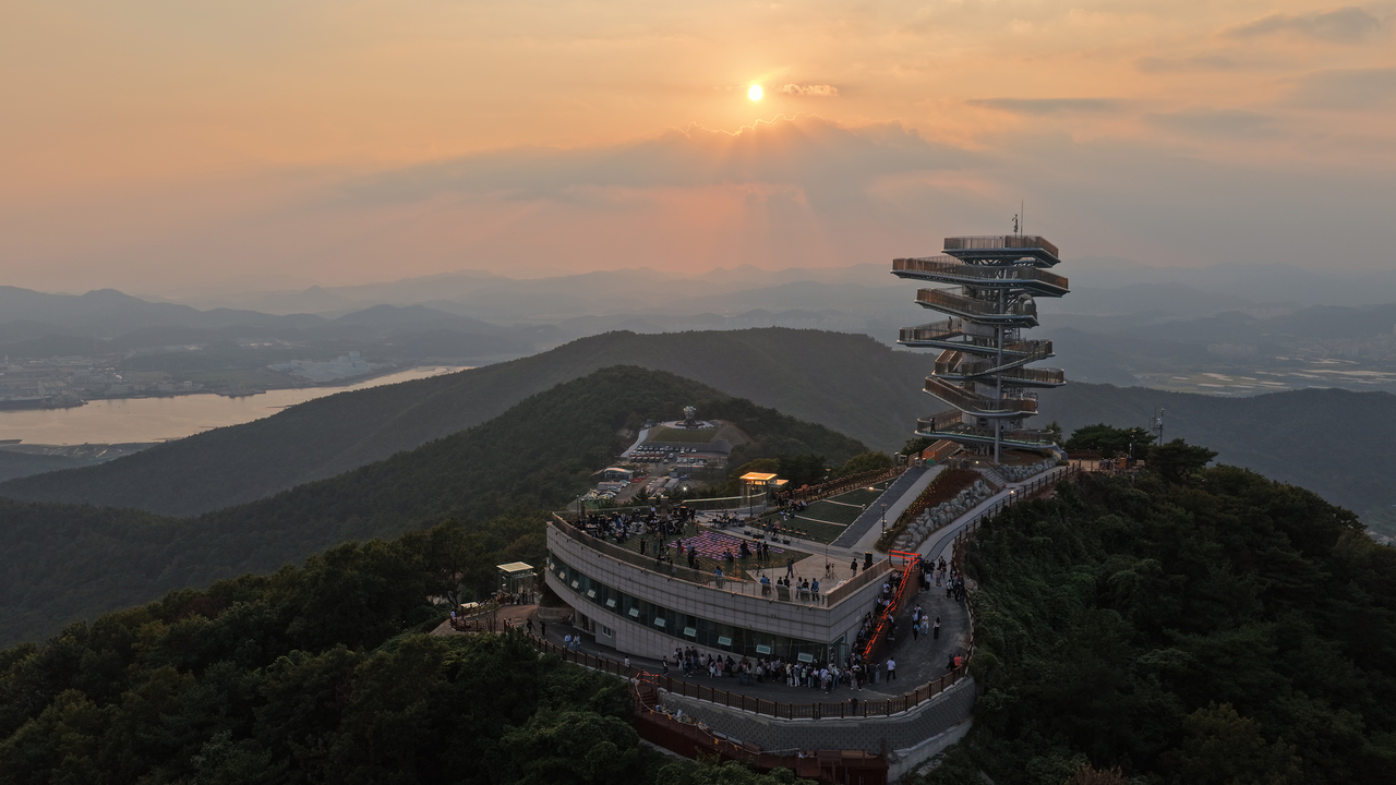 "Panorama Walk" bathed in the glow of sunset at the summit of Gubongsan in Gwangyang. Visitors can stroll along the curving structure as it spirals through seven turns, taking in views of Gwangyang Bay and the changing scenery across all four seasons. [Posco]