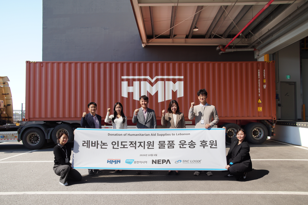 지난 6일 경기도 평택시 네파 스마트 물류센터에서 진행된 ‘레바논 인도적지원 물품 운송 후원’ 상차식에서 관계자들이 기념 촬영을 하고 있다. [HMM 제공]