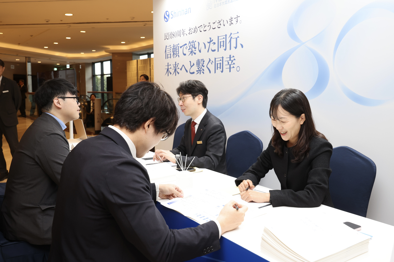 Shinhan Financial Group employees staff a promotional booth at the 80th anniversary ceremony of the Korean Residents Union in Japan, held Wednesday at Lotte Hotel World in Jamsil, Seoul, advising ethnic Koreans from Japan on opening bank and securities accounts and other financial services. [Shinhan Financial Group]