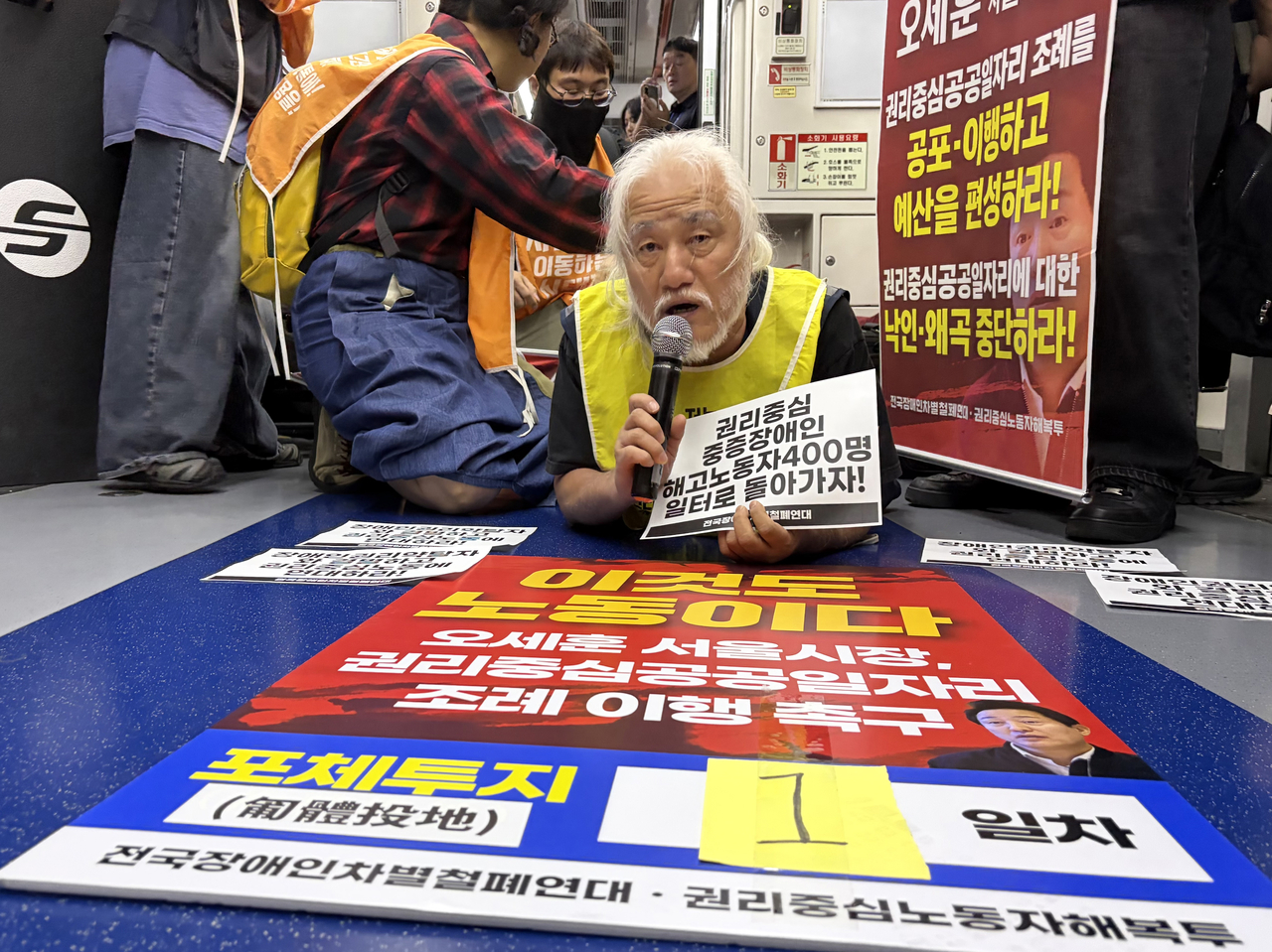 박경석 전장연 상임공동대표가 지난달 지하철에서 포체투지 시위를 진행하는 모습. [연합]