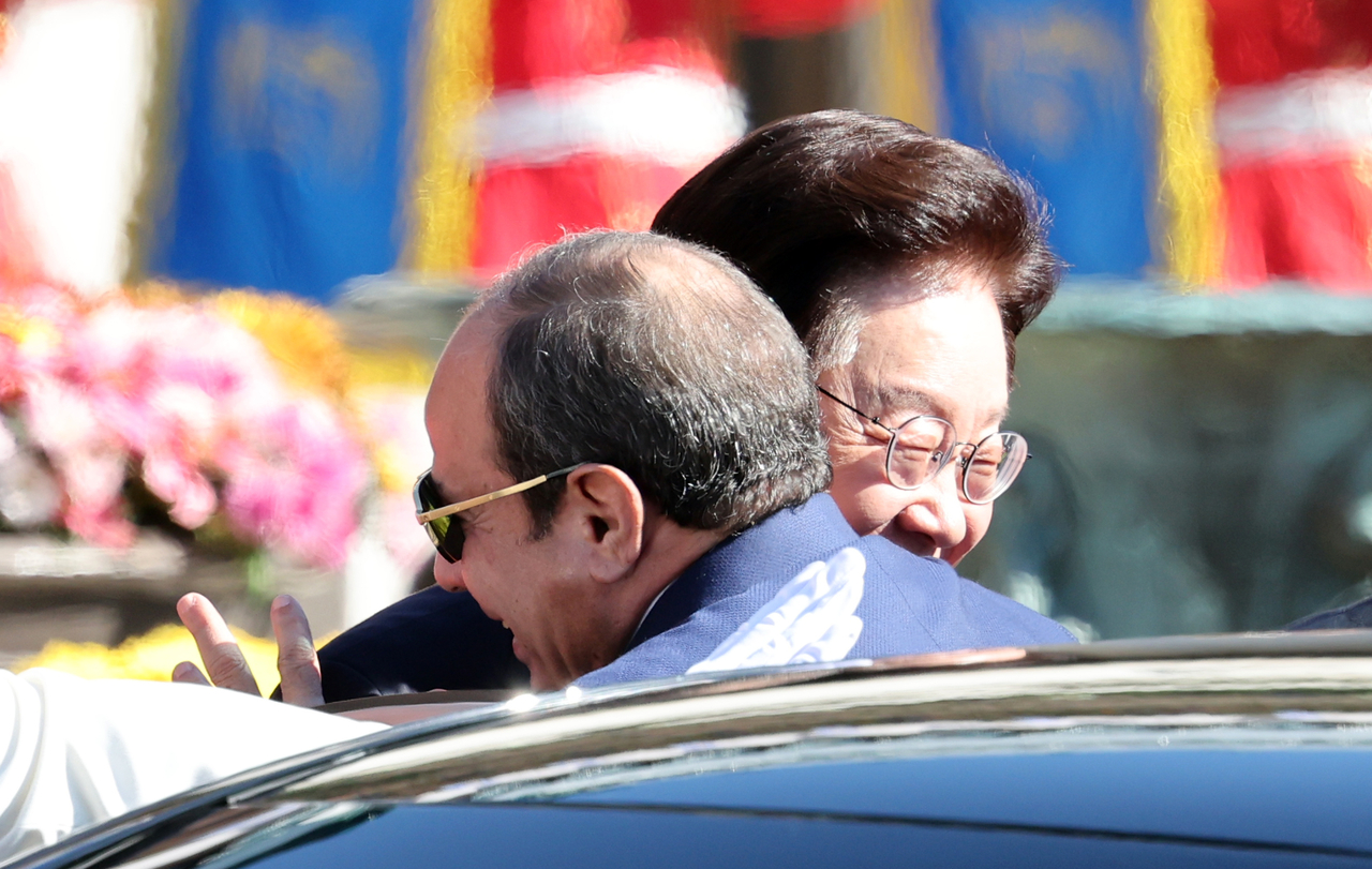 President Lee Jae Myung embraces Egyptian President Abdel Fattah el-Sissi as the Egyptian leader steps out of a vehicle upon arriving at Cheong Wa Dae in Seoul on Thursday. (Yonhap)