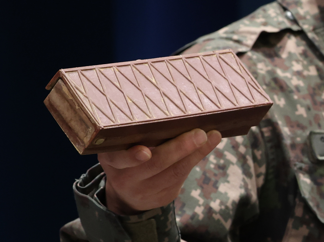 A South Korean military official hold up a disarmed North Korean mine at a briefing in Seoul on Monday. (Yonhap)