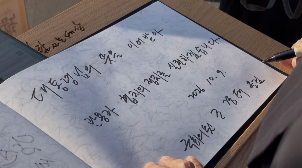 People Power Party lawmaker Cho Kyung-tae signs the visitor's book after paying his respects at the grave of former President Roh Moo-hyun in Bongha Village, Gimhae, South Gyeongsang Province, on Friday. [Yonhap]