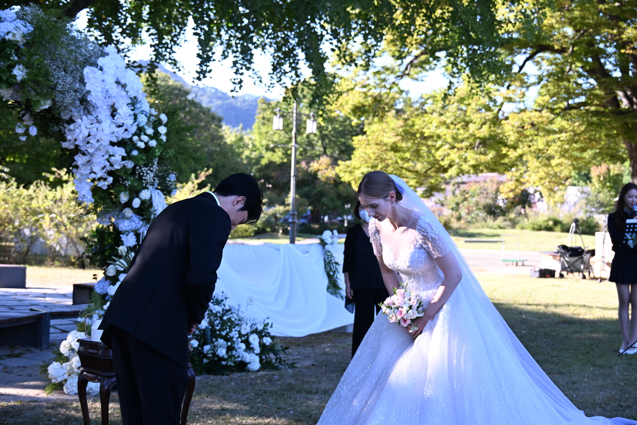 Estonian YouTuber Mai (right) gets married in a ceremony at the National Palace Museum’s ginkgo-tree rest area in Seoul on Oct. 2. (Korea Heritage Service)