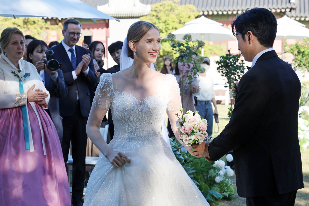 Estonian YouTuber Mai (left) gets married in a ceremony at the National Palace Museum’s ginkgo-tree rest area in Seoul on Oct. 2. (Newsis)