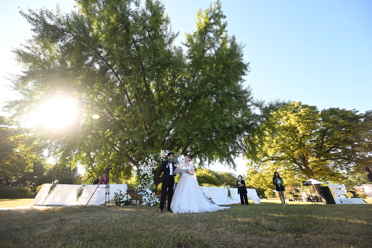 Estonian YouTuber Mai (right) gets married in a ceremony at the National Palace Museum’s ginkgo-tree rest area in Seoul on Oct. 2. (Korea Heritage Service)