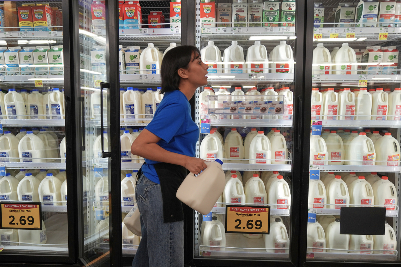 A shopper picks up a carton of milk at a grocery store in Fort Worth, Texas, on Wednesday. [AP]