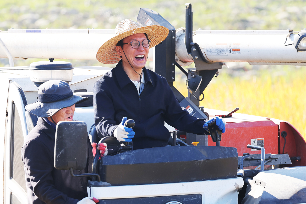Democratic Party leader Kim Min-seok tries his hand at harvesting rice in a paddy field in Anseong, Gyeonggi Province, on Thursday.