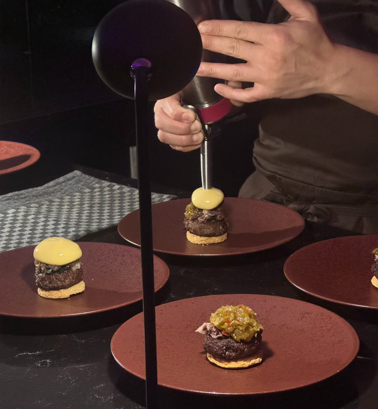 A chef spreads cheddar potato cream over the brisket patty during The Heel course at Burger King Korea's Seongsu flagship in Seoul. (No Kyuing-min/The Korea Herald)
