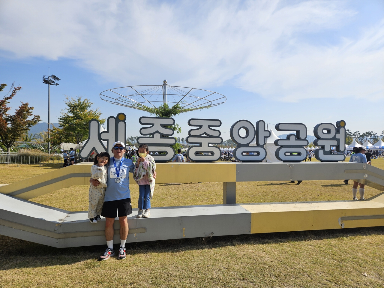 9일 세종중앙공원에서 열린 ‘2026 한글런’ 행사장을 찾은 정지원(맨 오른쪽) 어린이가 마라톤을 완주한 아버지, 동생과 함께 기념촬영을 하고 있다. [정지원 어린이 어머니 제공]
