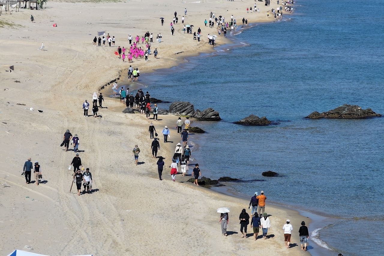 People walk along Mangsang Beach in Donghae, Gangwon Province, on a warm Saturday, Oct. 10. (Yonhap)