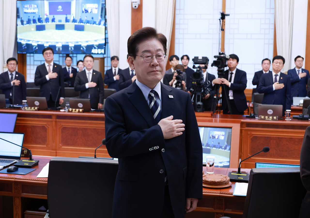 President Lee Jae Myung salutes the national flag at a Cabinet meeting held at Cheong Wa Dae on Tuesday. [Yonhap]