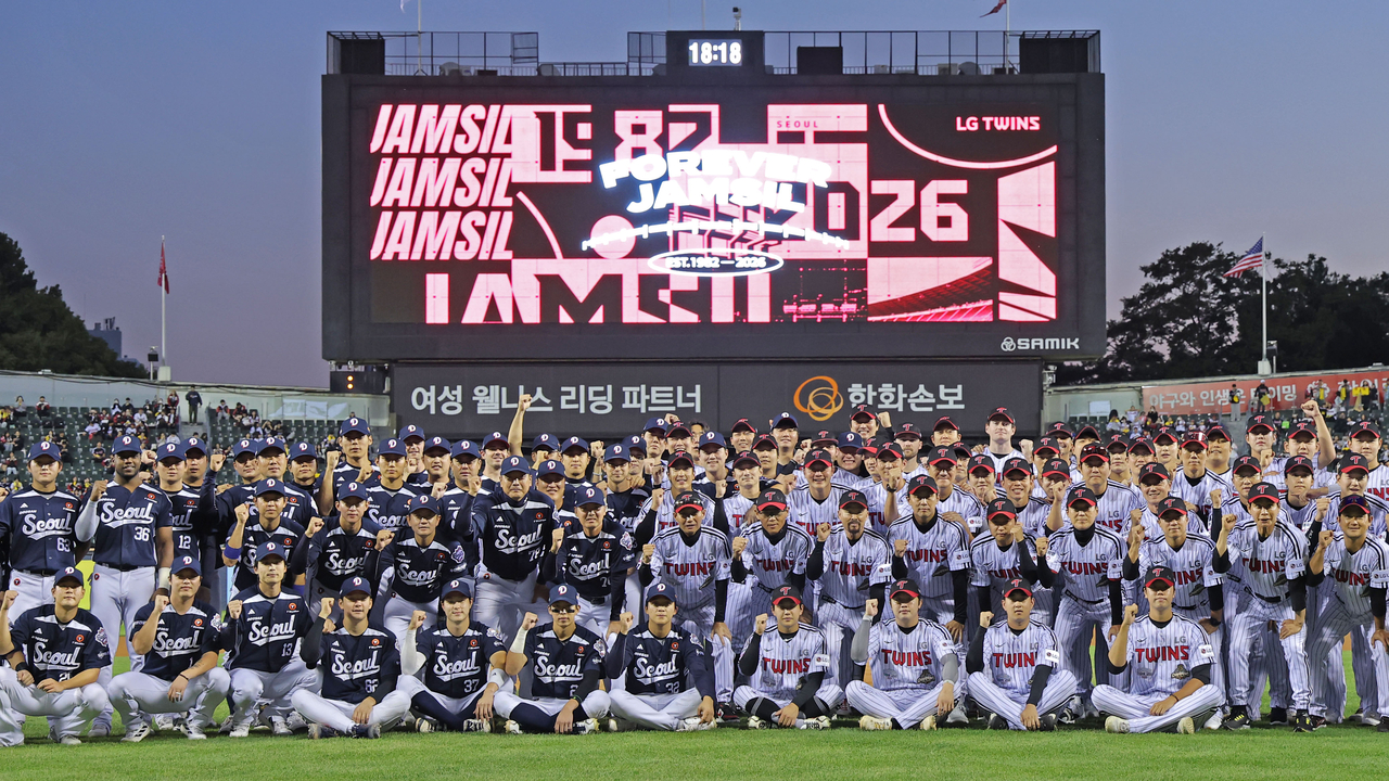 Players for the Doosan Bears (L) and the LG Twins pose for photos before playing their final Korea Baseball Organization regular-season meeting at Jamsil Baseball Stadium in Seoul on Wednesday. (Yonhap)