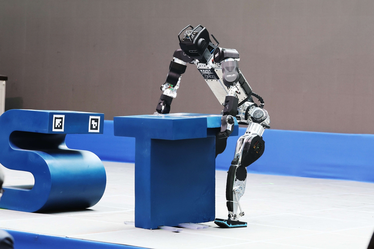 An AI-powered humanoid robot completes the word "KAIST" by lifting and moving the letter "T" during a demonstration held at the university's Daejeon campus on Tuesday. (KAIST)