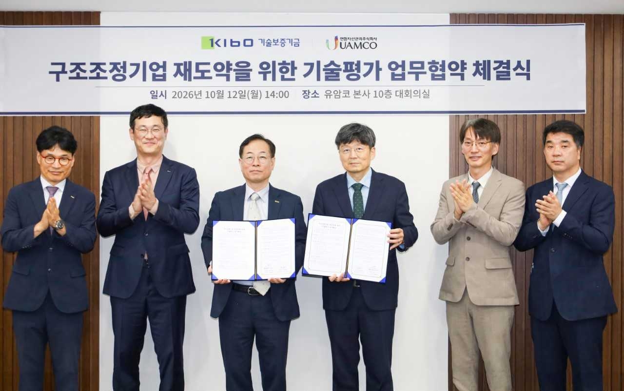 권형택 기술보증기금 이사장(왼쪽에서 세번째)과 김윤우 유암코 대표이사(왼쪽에서 네번째)를 포함한 협약참석자들이 업무협약 후 기념촬영을 하고 있다. [기술보증기금]