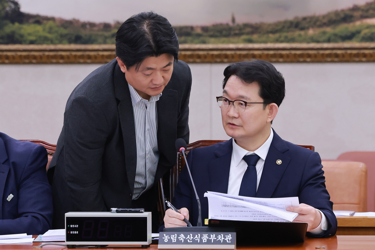 Vice Minister of Agriculture, Food and Rural Affairs Kim Jong-gu (right) reviews documents and speaks with a ministry official at a subcommittee meeting of the National Assembly's Agriculture, Food, Rural Affairs, Oceans and Fisheries Committee on Sept. 29. (Yonhap)