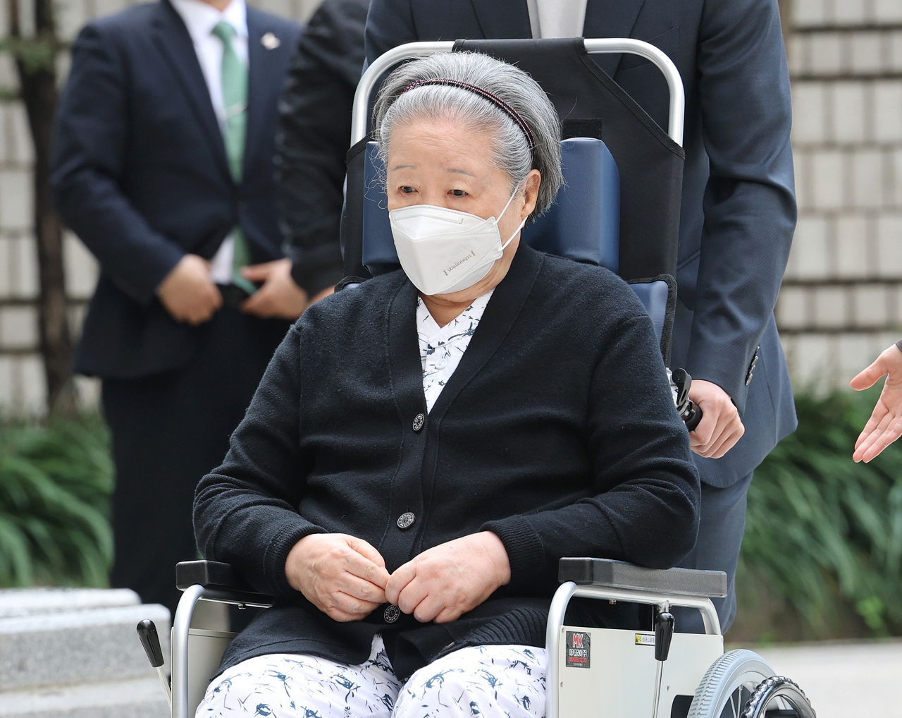Han Hak-ja, leader of the Unification Church, arrives at the Seoul High Court in a wheelchair and hospital gown on Tuesday for the first hearing of her appeal against a two-year prison sentence. Han has been temporarily released from detention on health grounds. (Yonhap)