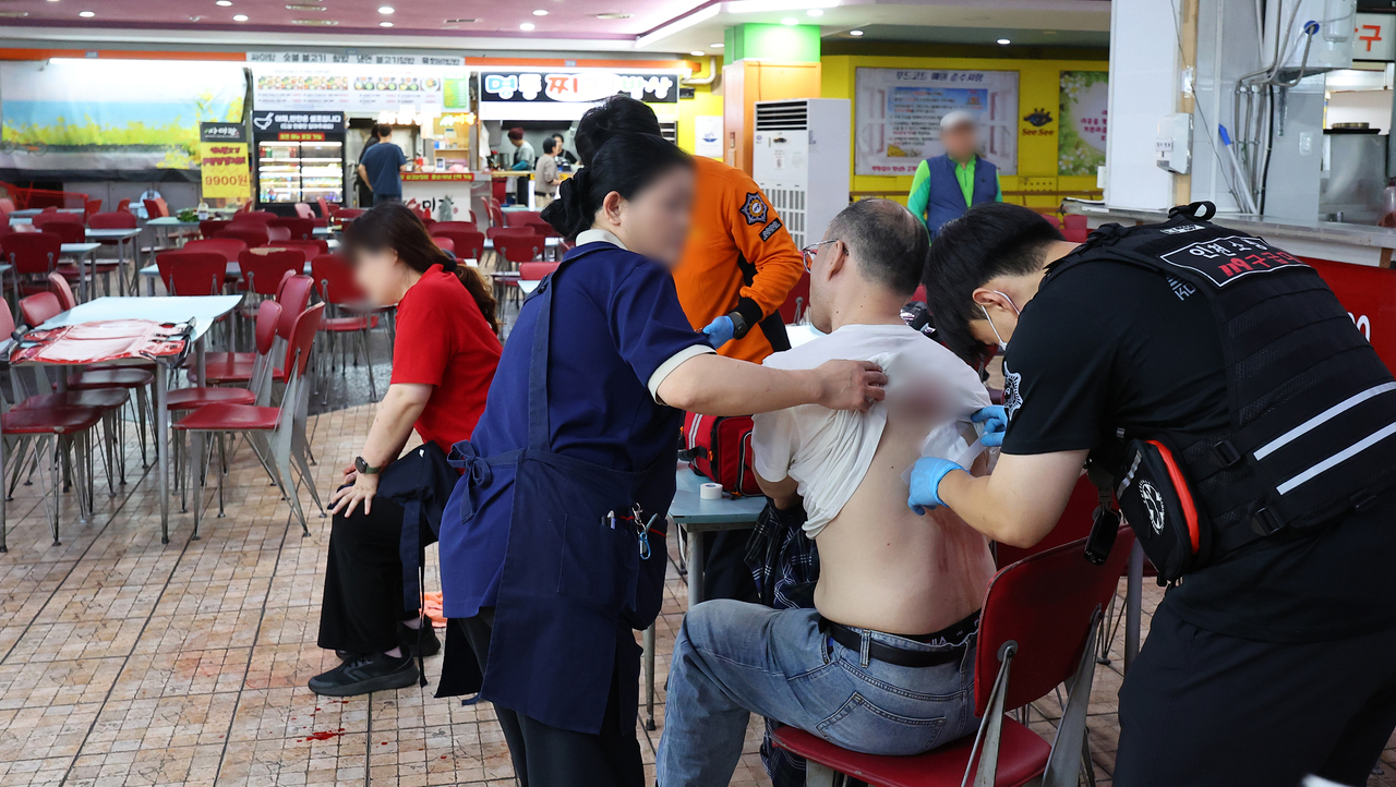 A person receives emergency treatment at a Homeplus store in Guwol-dong, Incheon, on Oct. 13, following a random stabbing attack. (Yonhap)