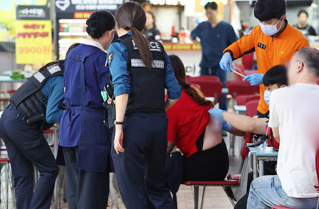 A person receives emergency treatment at a Homeplus store in Guwol-dong, Incheon, on Oct. 13, following a random stabbing attack. (Yonhap)