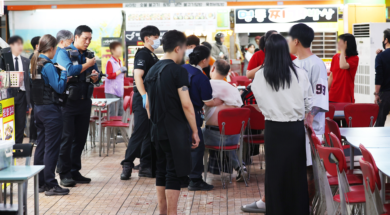 Police officers, rescue workers and Homeplus employees are seen at a Homeplus store in Incheon on Oct. 13 following a random stabbing attack. (Yonhap)