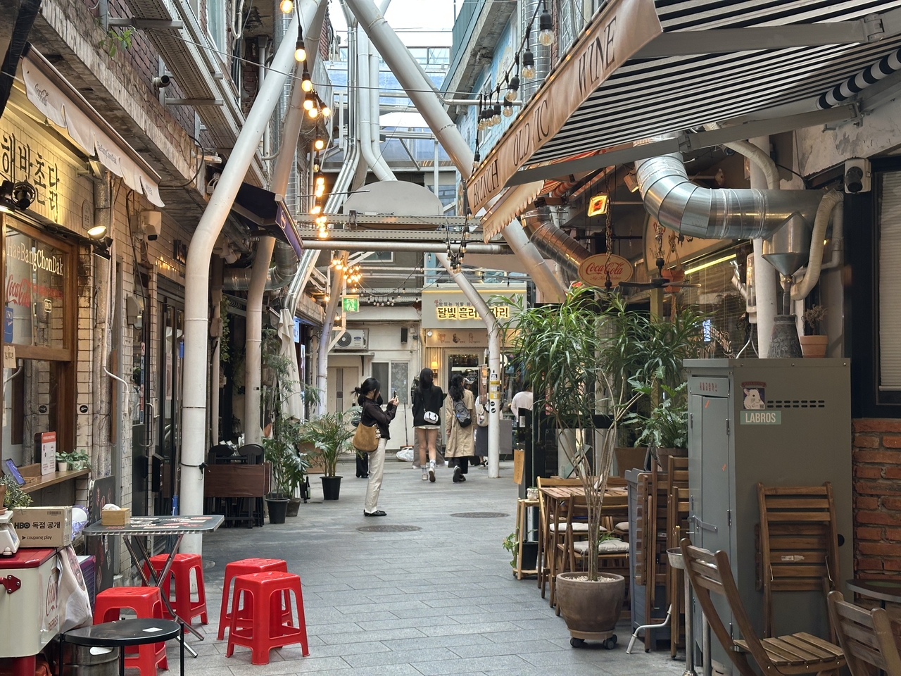 Visitors explore the narrow alleys lined with restaurants and cafes at Sinheung Market in Haebangchon, Seoul, on Thursday afternoon, Sept. 10. (Tammy Park/The Korea Herald)