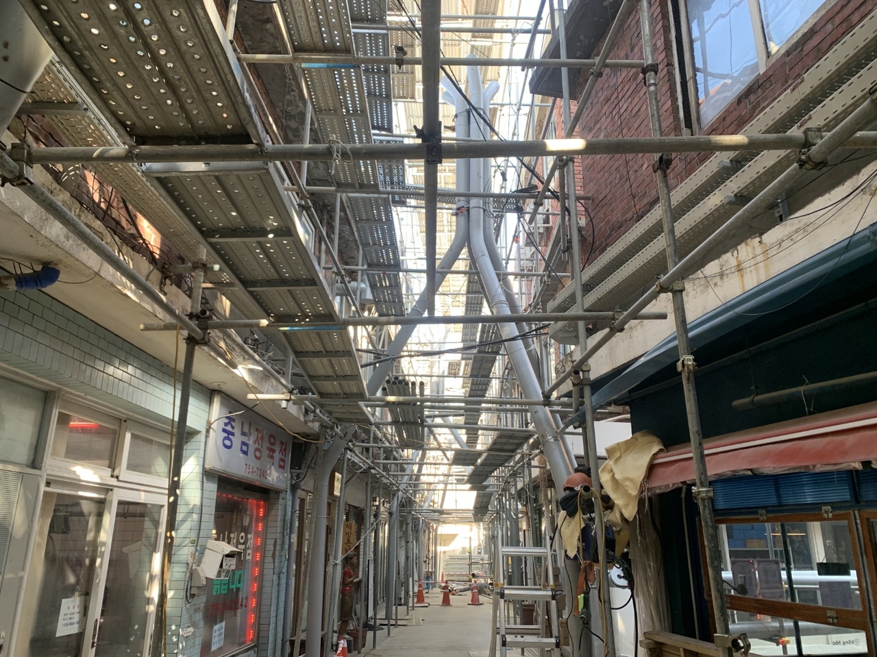 Scaffolding fills an alley in Sinheung Market during renovation work, in this undated photograph taken between 2021 and 2023. (Sinheung Market Merchants’ Association)