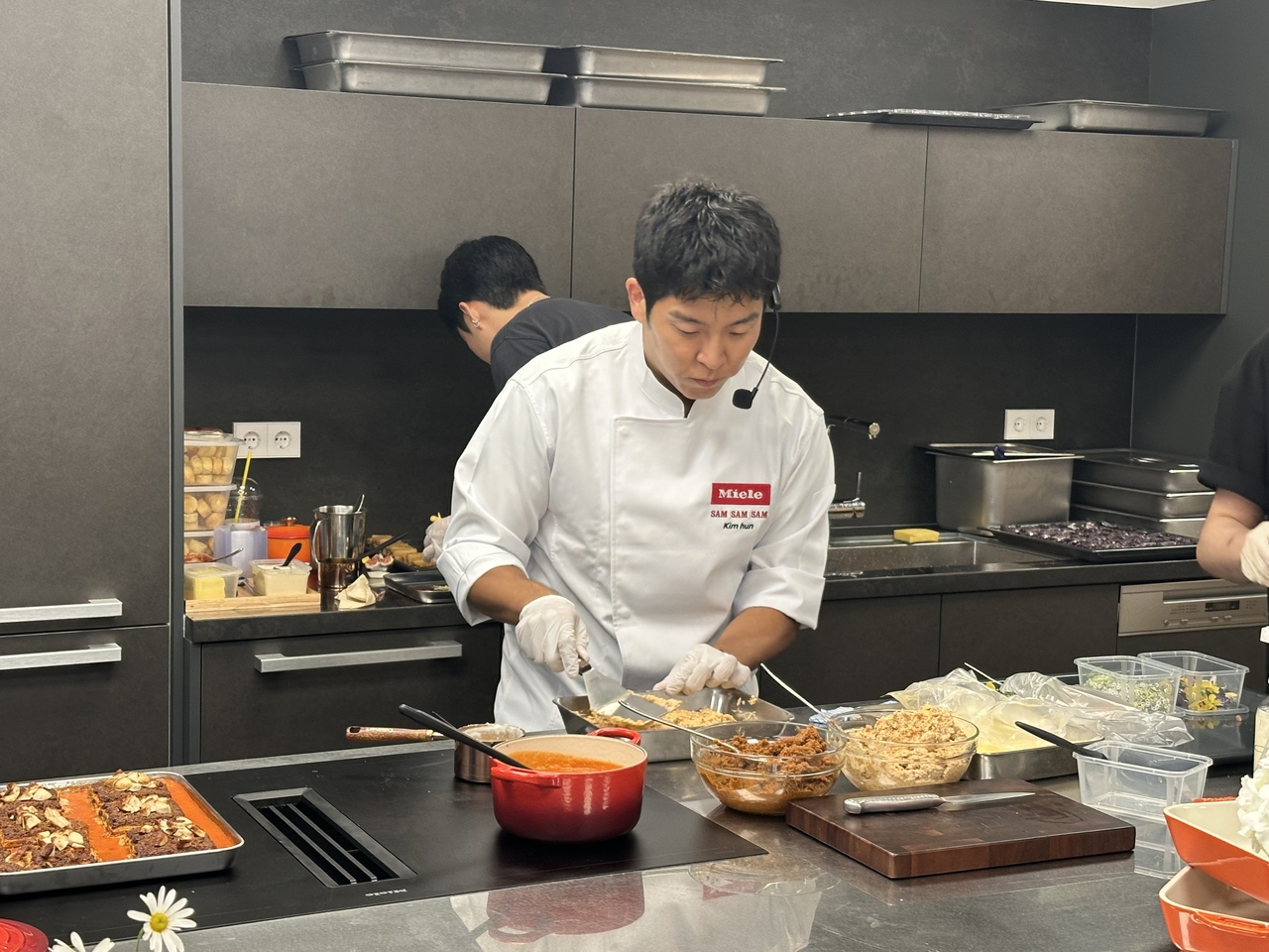 Chef Kim Hun of Ssaem Ssaem Ssaem performs a live cooking demonstration at the launch event for Miele's new hood-integrated induction cooktop at the Miele Experience Center Gangnam in Gangnam-gu, Seoul, on Tuesday. (Lee Jeong-wan)