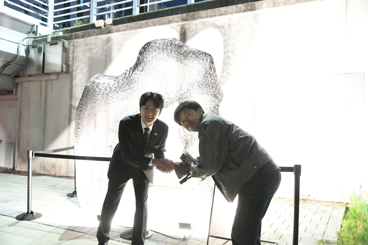 Nowon-gu District Mayor Seo Jun-o greets artistic director Jeon Yeong-il in front of an exhibition work at the Nowon Moonlight Walk.