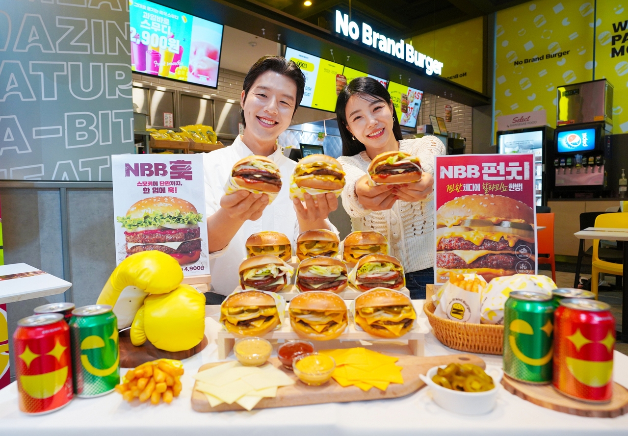 14일 서울 성동구 노브랜드 버거 성수랩점에서 모델들이 3세대 대표 메뉴 ‘NBB 훅’과 ‘NBB 펀치’를 소개하고 있다. [노브랜드 버거 제공]