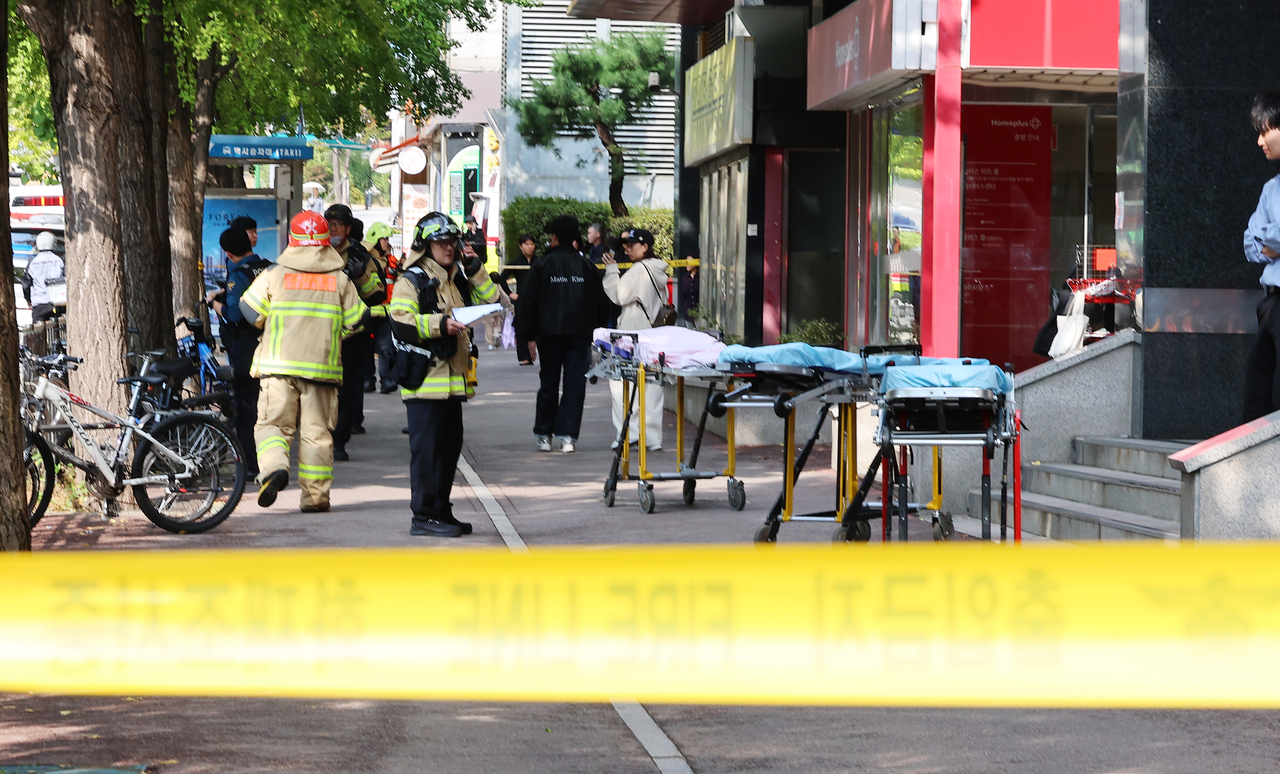Police and rescue officials are seen Tuesday at a commercial complex in Incheon, where a knife attacking spree left eight people injured. (Yonhap)