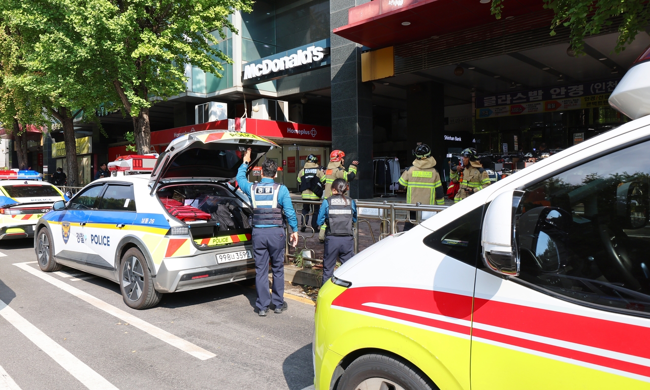 Police officers and rescue officials are dispatched at a commercial complex in Incheon, where a knife attack spree left eight people injured. (Yonhap)
