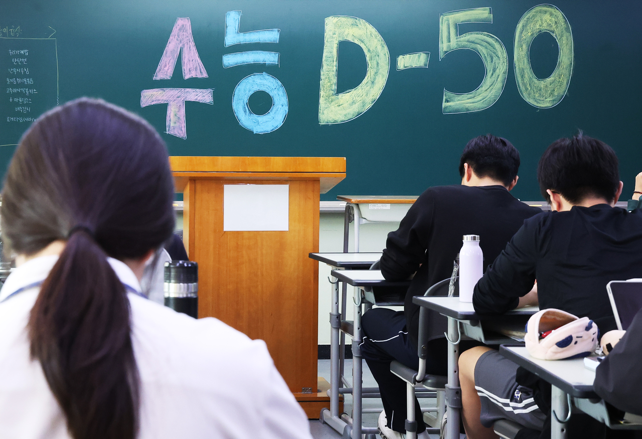Students  at a high school in Suwon, Gyeonggi Province, on Sept. 30, with a countdown to the Nov. 19 Suneung written on the blackboard. (Yonhap)