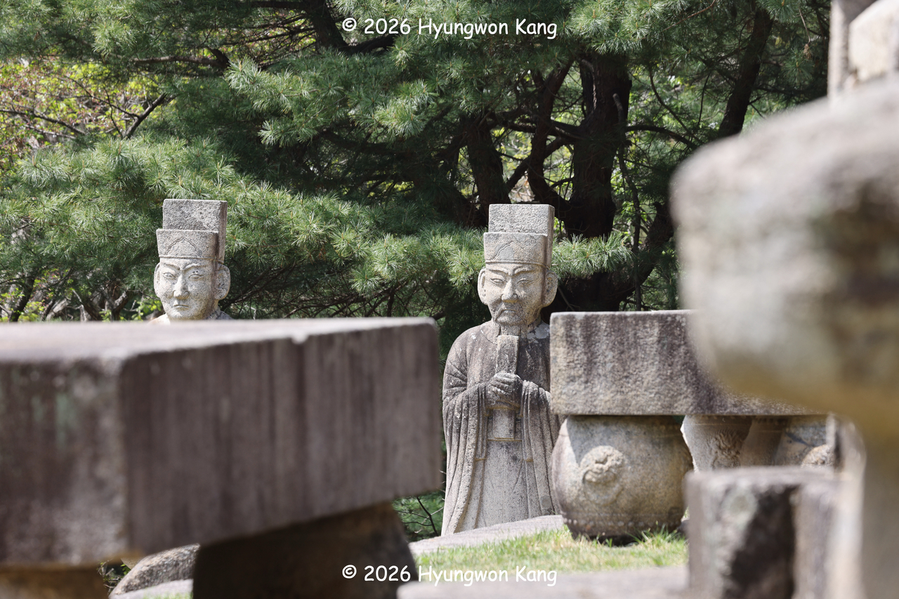 Two stone civil officials are visible between a pair of honyuseok ritual stone tables at Hyonjongnung in Kaesong, North Korea, at the paired royal tombs of King Gongmin and Princess Noguk. (Hyungwon Kang)