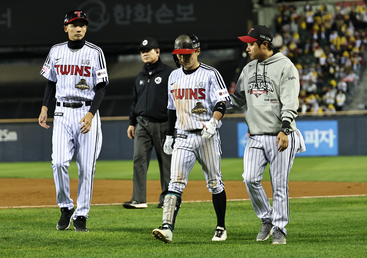 Shin Min-jae of the LG Twins (C) walks off the field after suffering a hamstring injury on a squeeze bunt against the Doosan Bears during the clubs' wild card game in the Korea Baseball Organization postseason at Jamsil Baseball Stadium in Seoul on Wednesday. (Yonhap)