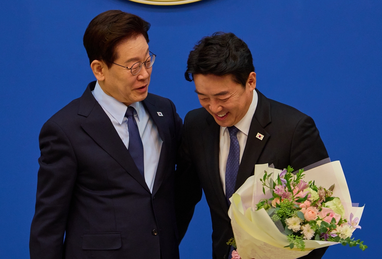 이재명 대통령이 15일 청와대에서 강훈식 전 비서실장에게 공로패를 전달하고 포옹을 나눈 뒤 담소를 나누고 있다. [청와대 제공]