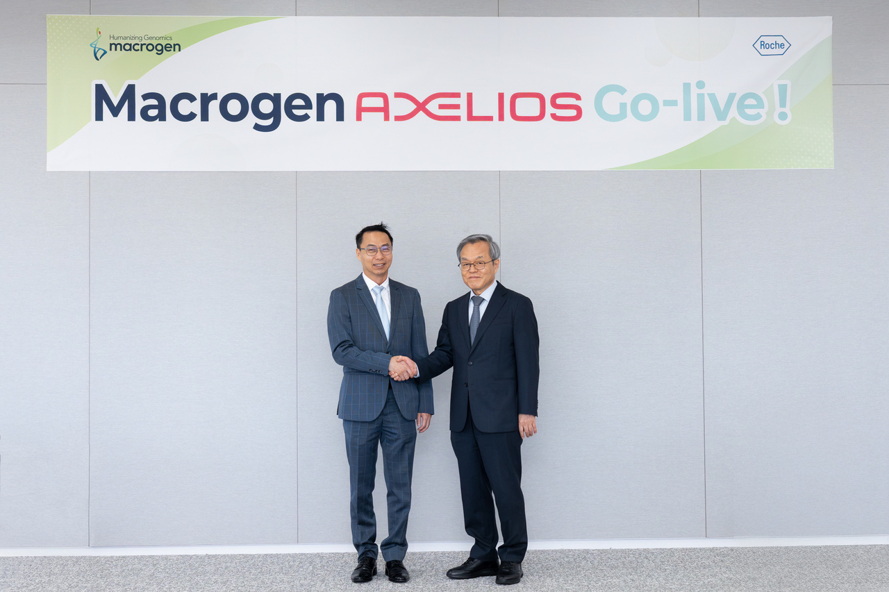 Roche Diagnostics Korea CEO Kit Tang (left) and Macrogen Chair Seo Jeong-sun shake hands at Macrogen's Songdo Global Genome Center in Incheon on Wednesday to mark the launch of the Axelios 1 genome sequencing platform. (Macrogen)
